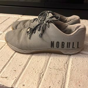 Small rip in the side (shown in photos). Very nice used Nobull Trainer Plus